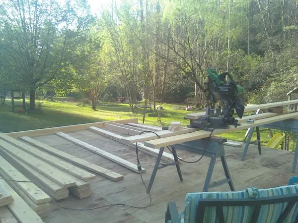 Miter saw and framing lumber on a deck under construction in Melvin Village